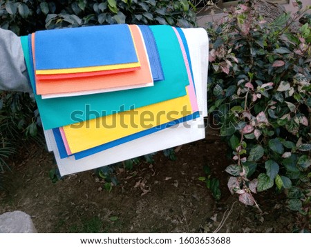 colorful exo friendly non woven bags on green plant