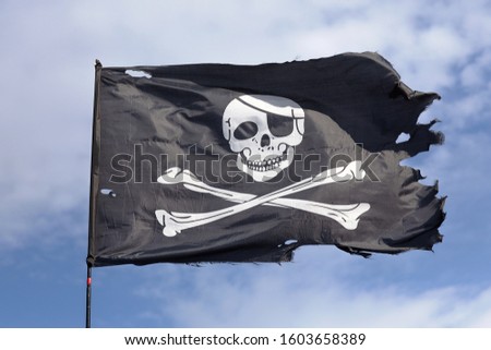 jolly roger. pirate flag.Against the background of blue sky.
