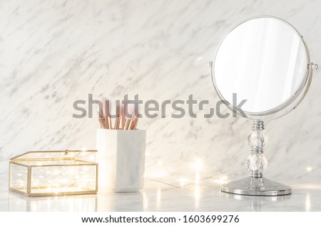 Dressing table with mirror on marble background. Royalty-Free Stock Photo #1603699276