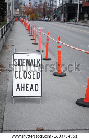 "Sidewalk Closed Ahead" sign along a roadside construction site