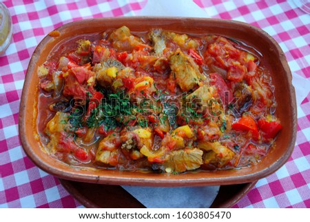 Traditional Serbian Leskovacka Muckalica - a spicy stew of pork, tomatoes and peppers prepared in a clay pot Royalty-Free Stock Photo #1603805470