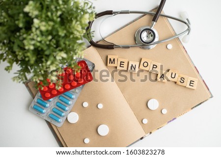 Concept. The inscription from the letters menopause. Symptoms of Menopause Harmonious changes in women older than 40 years. Royalty-Free Stock Photo #1603823278
