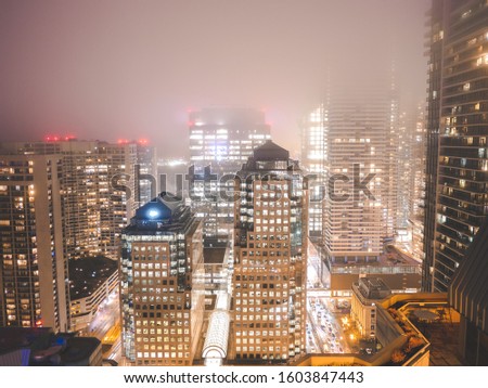 Toronto buildings on a foggy night within the city lights.