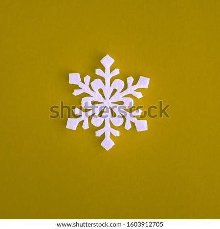Christmas holidays composition, top view white snowflakes decoration on yellow background with copy space for text. Flat lay. Winter, postcard template