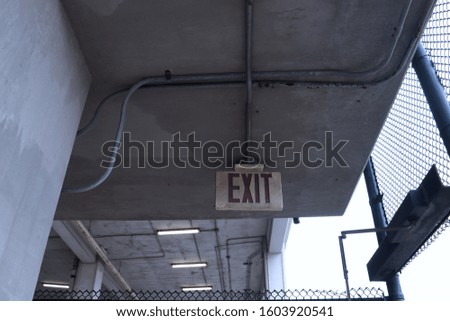 Exit sign of a parking concrete building urban style cold colors grey and blue lights