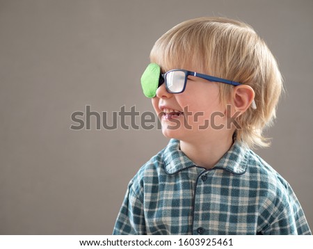 Portrait of funny child in new glasses with green spot to correct strabismus
Orthopedic Boys Eye Patches nozzle for glasses for treatment of strabismus (lazy eye). Boy puts on and corrects glasses Royalty-Free Stock Photo #1603925461