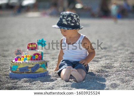 Sweet boys, celebrating on the beach birthday with car theme cake and decoration, summertime