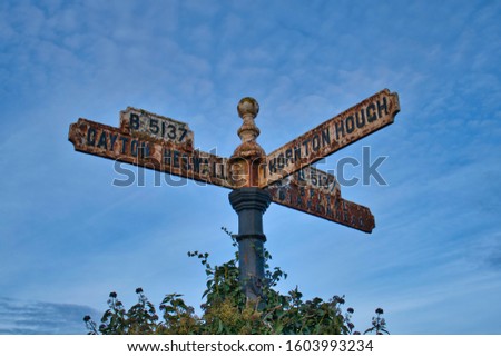 An old, rusting sign showing directions to Gayton, Heswall, Thornton Hough and Birkenhead in Wirral, UK