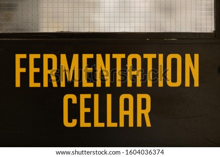 fermentation cellar yellow vinyl sticker text Information sign on a black door, industrial room symbol, selective focus and close up view