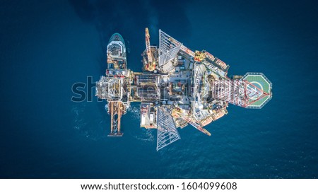 Top down aerial view of a jack up rig in the open ocean captured by drone.