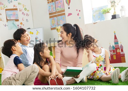 Kindergarten teacher tells the children stories Royalty-Free Stock Photo #1604107732