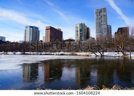 Cold winter January landscape view of east side of city Milwaukee, Wisconsin mirroring off a river at a park. 