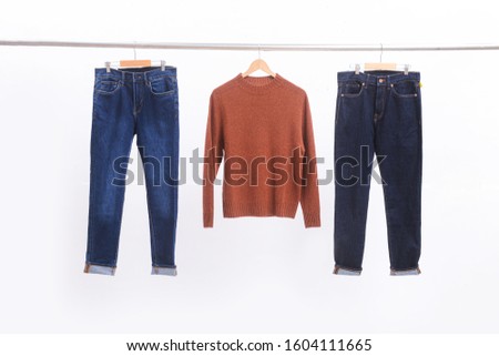Brown sweater and two blue jeans Isolated on hanger

