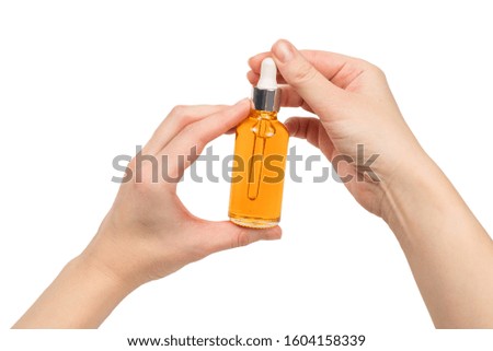 Bottle with oil in woman hand isolated on white. Copy space.