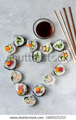Set sushi roll in the shape of a heart on a stone table. Valentine's day romantic menu, dinner lovers. banner food delivery Valentine's day. Top view of assorted sushi, uramaki, hosomaki and nigiri.