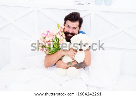 womens day. flowers for march 8. good morning surprise. happiness about present. cheerful bearded man in bed. happy birthday gift. spring fresh tulip and bear toy. love valentines day. I am sorry.