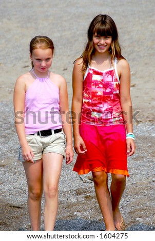 Two preteen girls walking on a beach