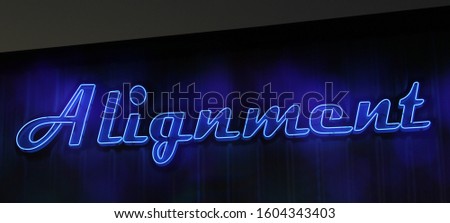 Vintage Blue Neon Alignment Sign on Metal Building at Night