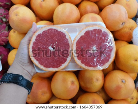 Fresh cut red ruby grapefruit wrapped placed on foam plate for sale in supermarket. 