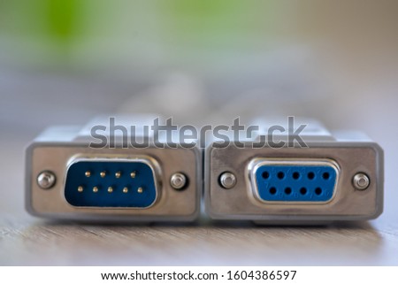 Close-up of a RS-232 serial port. Male to female extension cord on a wooden table. Royalty-Free Stock Photo #1604386597