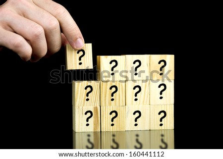 Male hand placing last piece of a cube with question mark.