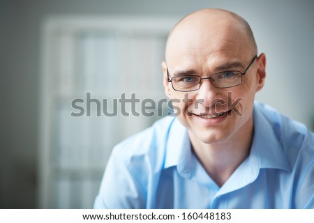 Portrait of attractive businessman in eyeglasses looking at camera