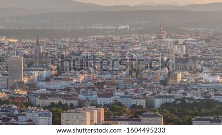 Aerial panoramic view of Vienna city with skyscrapers, historic buildings with spires and mountains on a background timelapse in Austria. Evening skyline before sunset from Danube Tower viewpoint
