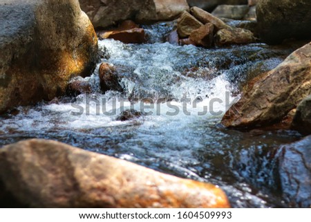 water flowing over rocks. Waterfall in nature and springtime outdoor adventure
