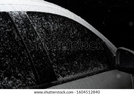 Snow covered car at night