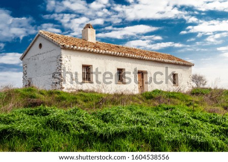 Grass and white countryhouse in Villarrubia de los Ojos.. Ciudad Real. Spain. Europe. Royalty-Free Stock Photo #1604538556