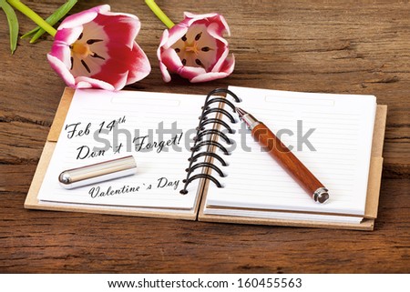 Valentine's Day Event Reminder with a Flower, Notepad with Pen on old Wooden Background