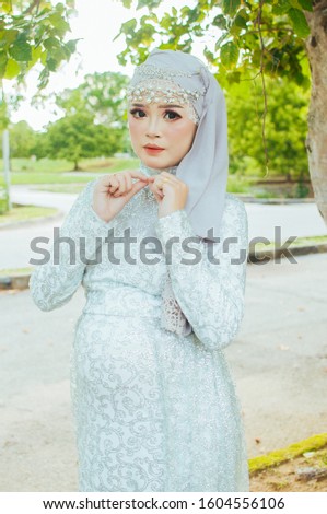 Hijab women who is 5 months pregnant pose