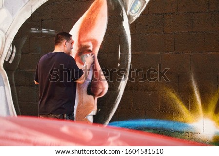 graffiti artist doing graffiti on the street Royalty-Free Stock Photo #1604581510