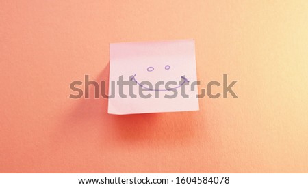 paper sticker with smile painting expressing on orange background               