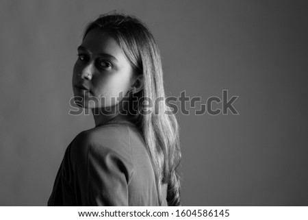 Young woman in brown. Young woman looking at camera. Black and white picture.