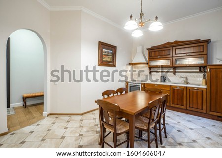Luxury interior of kitchen in modern apartment. Wooden furniture. Entrance arch.