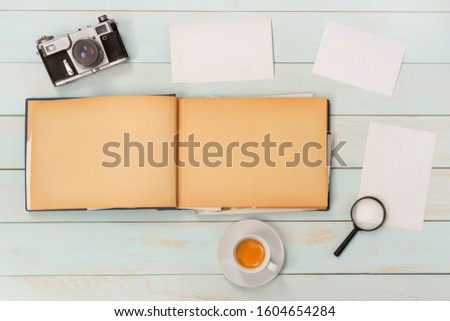 Old photo album with photos on a  wooden table and old cameras.Mockup free.Copy space.