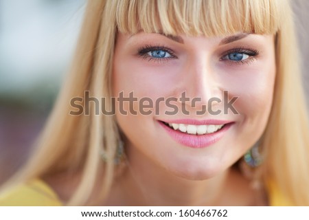 Happy smiling woman portrait outdoors. Beautiful teenager girl smiling. Attractive young woman at street with white healthy teeth. Portrait Of Young Smiling Beautiful Woman