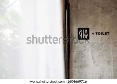 toilet sign on cement wall with soft light