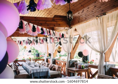 Decorated with balloons and ribbons birthday terrace. Pink and black decoration. Birthday party
