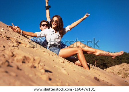 Young pretty cute couple in love having fun and laughing together on the beach in summer time. 