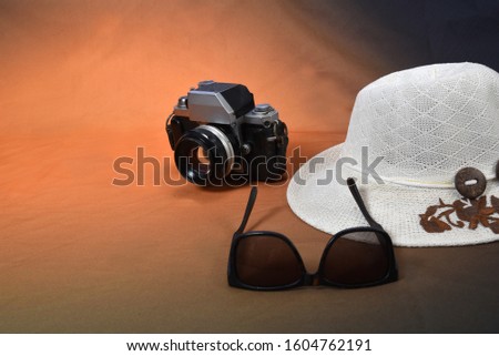 Traveler's accessories, photo camera, summer sun hat with empty empty space for text. Travel vacation concept. Summer background. Road frame set. Lay flat, top view.