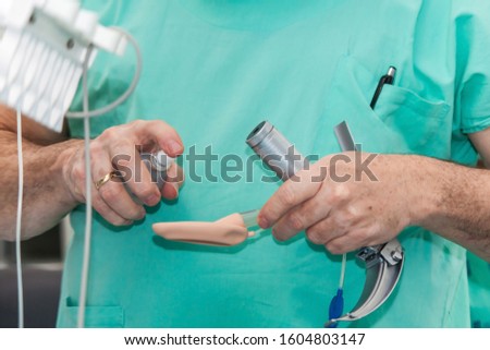 Anesthesiologist performing an endotracheal intubation to a female patient at the beginning of a surgery Royalty-Free Stock Photo #1604803147