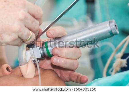 Anesthesiologist performing an endotracheal intubation to a female patient at the beginning of a surgery Royalty-Free Stock Photo #1604803150
