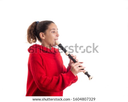 teenage girl playing the flute or recorder isolated on white background Royalty-Free Stock Photo #1604807329