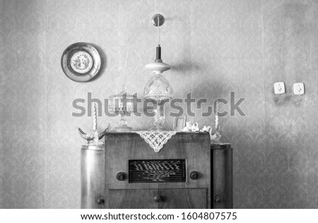 Vintage old radio on sixties, seventies wallpaper and furniture, antique, black and white 