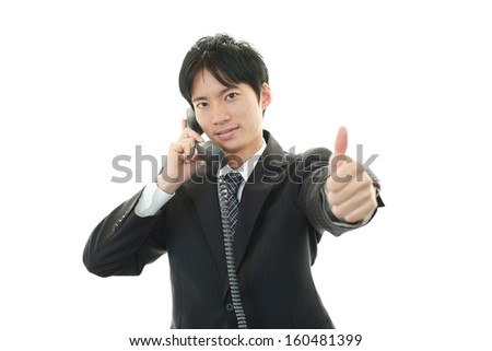 Happy business man showing thumbs up sign