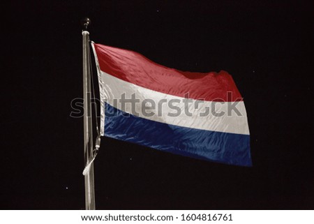 Netherlands flag blowing in the wind at night