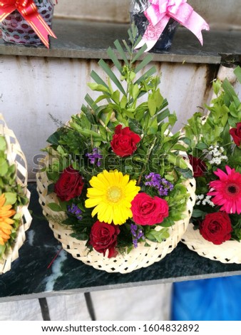 The picture of a beautiful four red roses bouquet with one sunflower in the middle of the bouquet. 