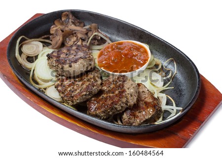 Medallions of beef with mushrooms and onions in the frying pan.